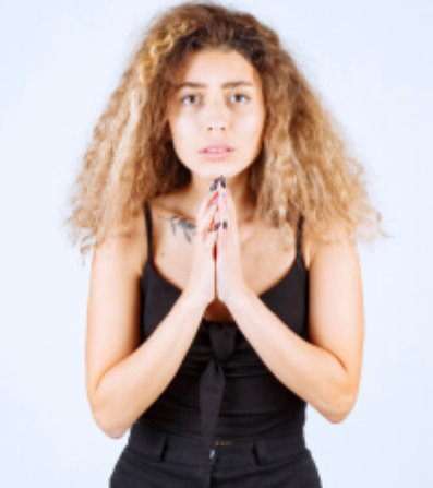 Woman making a praying hand sign